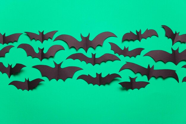 Halloween paper vampire bat decorations on a green background