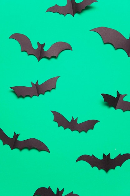 Halloween paper vampire bat decorations on a green background