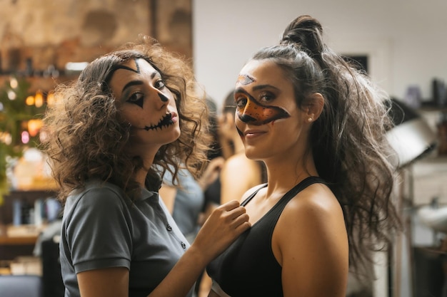 Halloween party preparations portrait of female friends in makeup before putting on costume