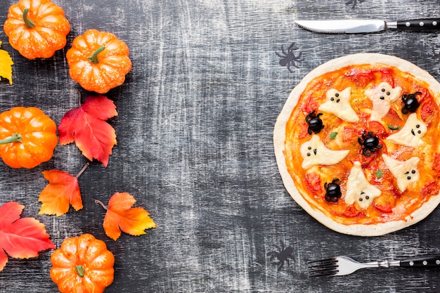 Foto pizza di halloween con zucca e foglie