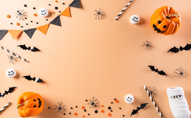 Halloween plat met decoraties gemaakt van pompoen, papieren vleermuizen en zwarte spin