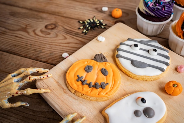 Halloween pompoen cupcake en zelfgemaakte koekje voor kind in herfst seizoen thuis.