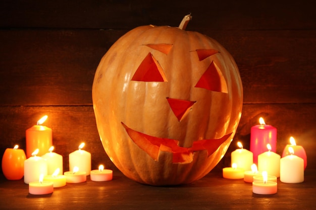 Halloween-pompoen en kaarsen op houten achtergrond