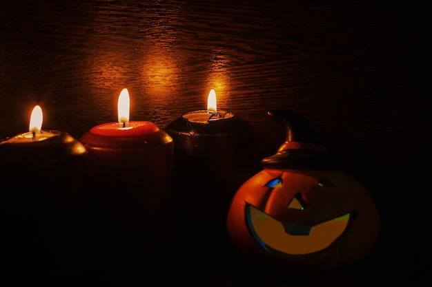 Halloween-pompoen met eng gezicht en kaarsen op zwarte achtergrond