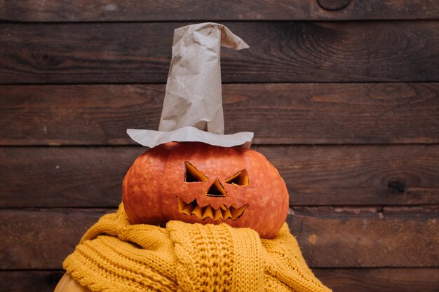 Halloween-pompoen met heksenhoed op houten achtergrond