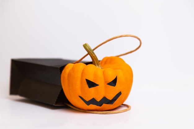 Photo halloween pumpkin and black paper bag isolated