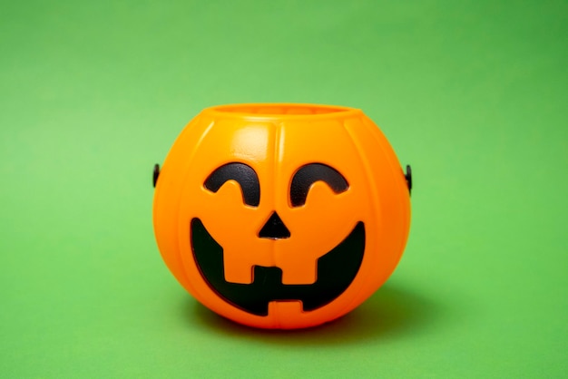 Halloween pumpkin closeup on a green background jack o lantern autumn holiday Decorations for the holiday All Saints39 Day trick or treat Candy bowl for sweets Kids fun