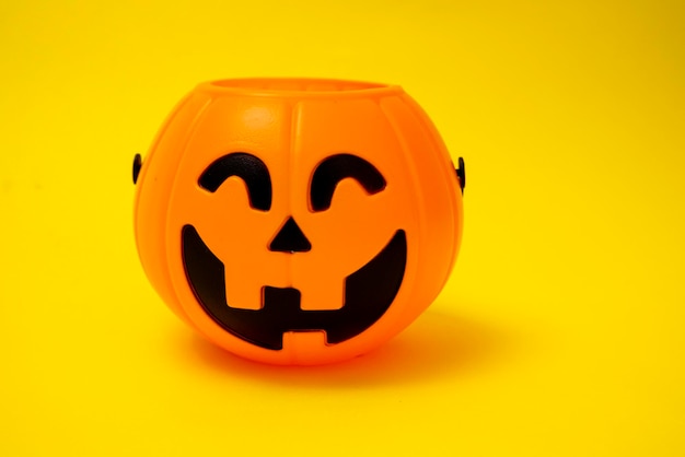 Halloween pumpkin closeup on an yellow background jack o lantern autumn holiday Decorations for the holiday All Saints39 Day trick or treat Candy bowl for sweets Kids fun