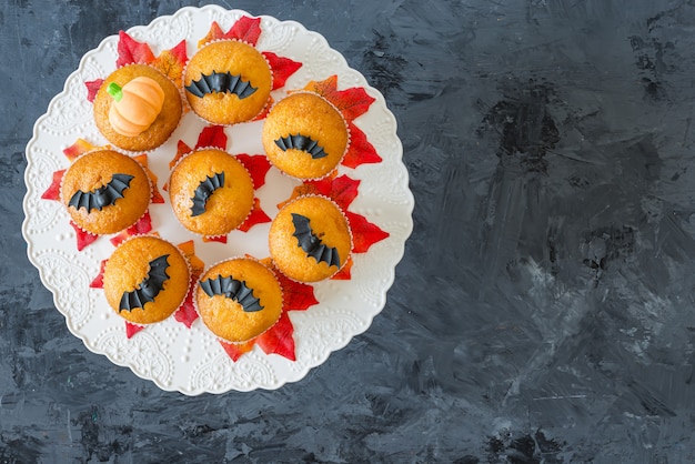 Halloween pumpkin cupcakes served on black , , top view, flat lay, copyspace 