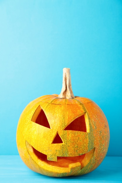 Halloween pumpkin head jack lantern on blue background.