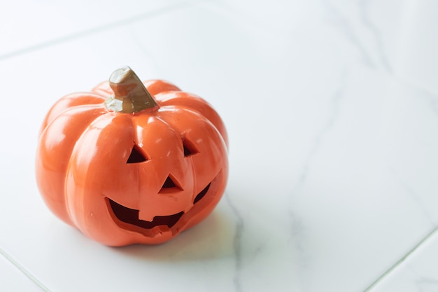 Halloween pumpkin head jack lantern on white marble floor