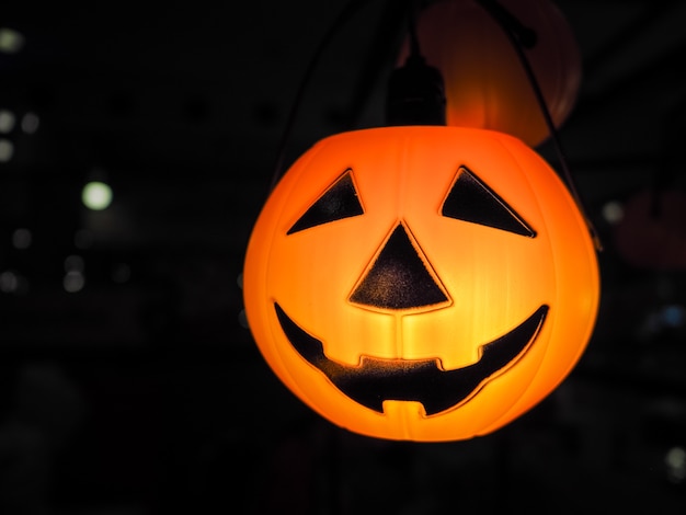 Halloween pumpkin head jack lantern with lighting over black background. Halloween celebra