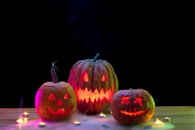 Foto lanterna della presa della testa della zucca di halloween con i fronti e le candele spaventosi diabolici