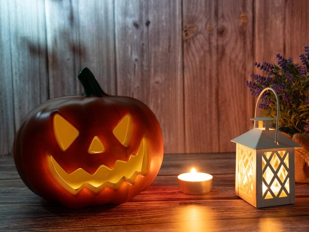 Хэллоуин тыквенный фонарь со свечами и тыквой на деревянном фоне