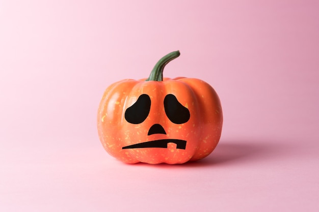 Zucca di halloween su sfondo rosa pastello.