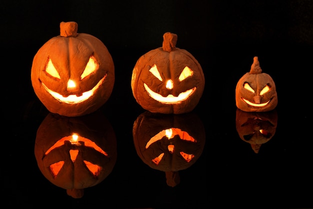 Zucca di halloween con candele accese su sfondo nero