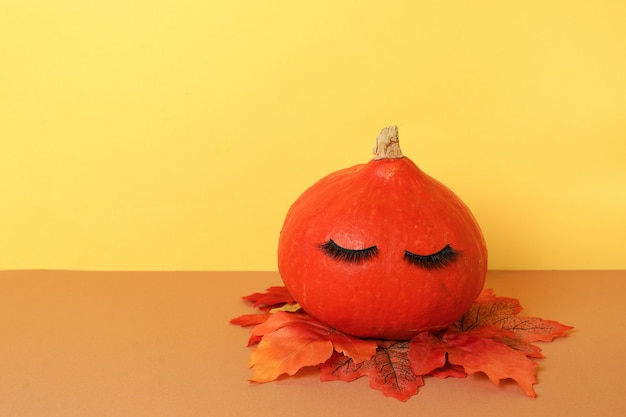 Halloween pumpkin with make up false eye lashes. Halloween Holiday season concept background