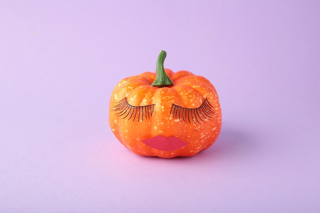 Halloween pumpkin with make up. Minimal Holiday season concept background. top view