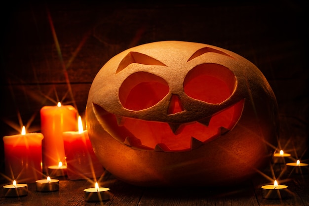 Foto zucca di halloween con viso spaventoso e candele