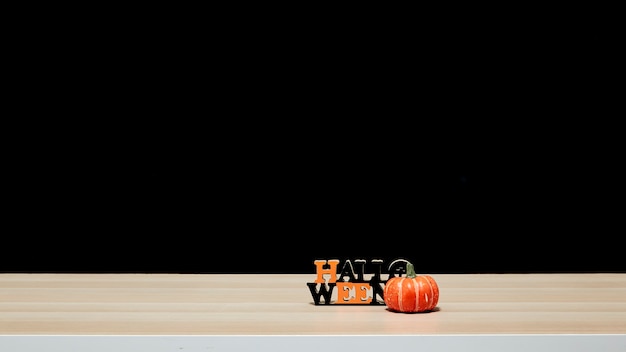 Halloween pumpkin on wood table black wall dark background