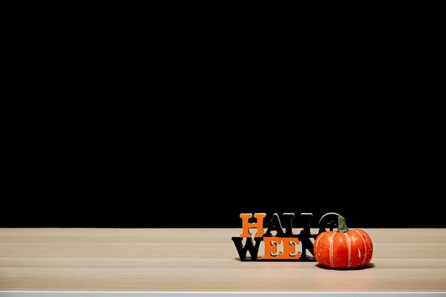 Halloween pumpkin on wood table black wall dark background