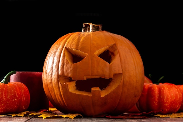 Foto zucca di halloween sul tavolo in legno e sfondo nero