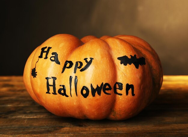 Halloween pumpkin on wooden table on dark color background