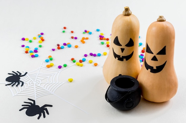 Хэллоуинские тыквы, силуэты летучих мышей, силуэт паутины и бумажные пауки на белом фоне