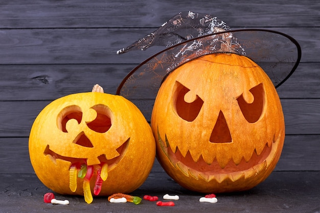 Halloween pumpkins on dark wooden background.