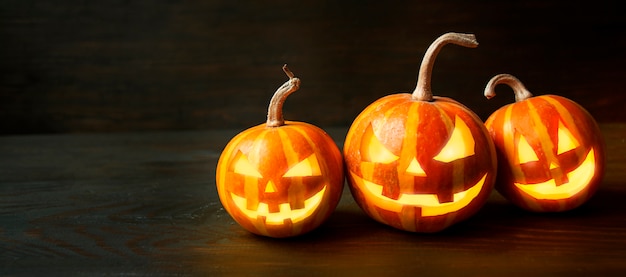 Halloween pumpkins on a dark wooden table. Halloween background.