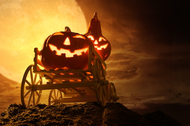 Zucche di halloween sul vagone dell'azienda agricola a spettrale nella notte della luna piena