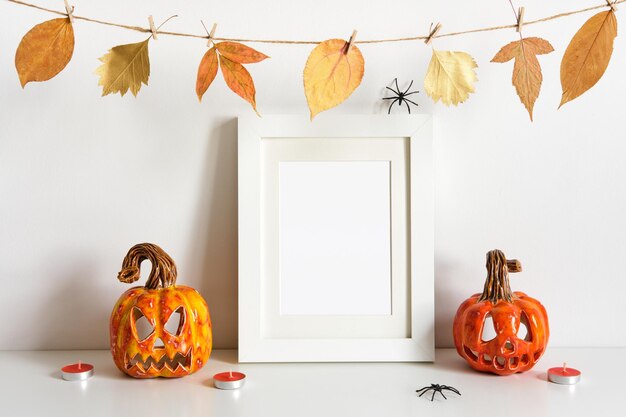 Halloween pumpkins floral garland and frame on table wall background greeting card template