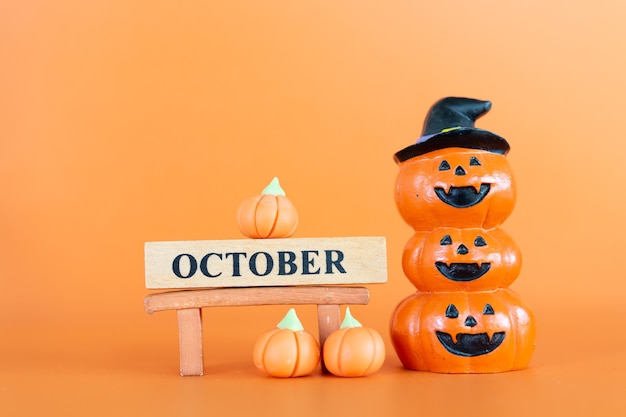 Halloween pumpkins (Jack-o'-lantern) on orange background, Hello October concept