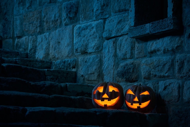 Halloween pumpkins jack p lantern in the yard of an old castle at night in the bright moonlight