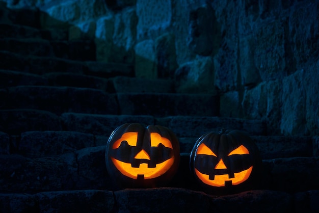 Halloween pumpkins jack p lantern in the yard of an old castle at night in the bright moonlight