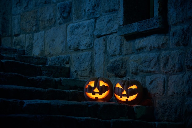 Halloween pumpkins jack p lantern in the yard of an old castle at night in the bright moonlight