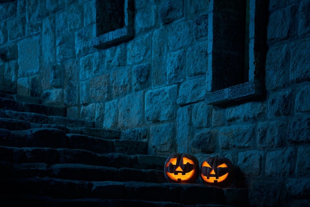 Halloween pumpkins jack p lantern in the yard of an old castle at night in the bright moonlight