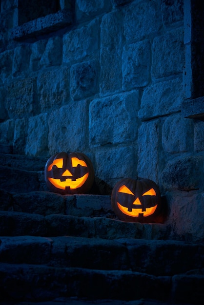 Halloween pumpkins jack p lantern in the yard of an old castle at night in the bright moonlight