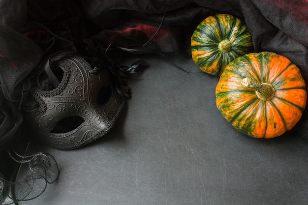 Le zucche di halloween e la maschera in maschera su sfondo grigio simulano il concetto di happy thanksgiving day