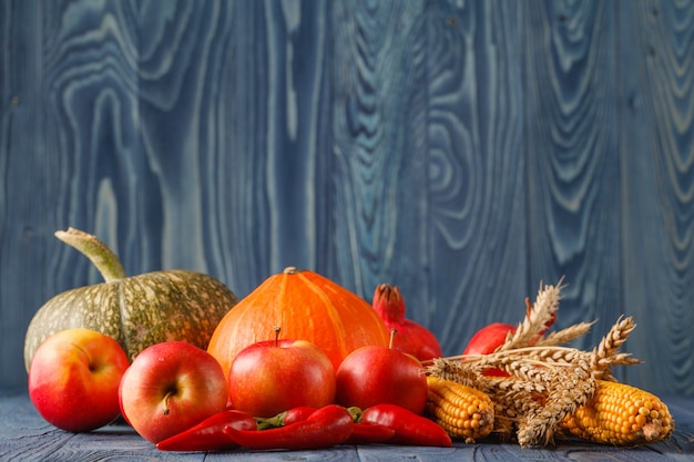 Halloween pumpkins in rattan basket in front of old weathered wooden boards in blue sunset light