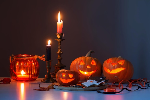 halloween pumpkins with burning candles on white table