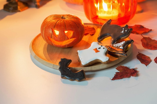 halloween pumpkins with burning candles on white table