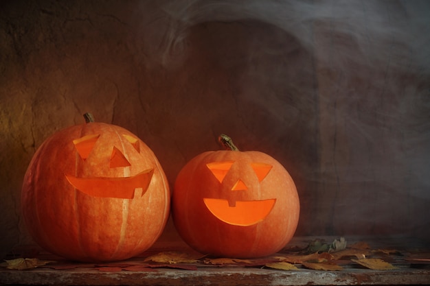 Halloween pumpkins on wooden table on dark background