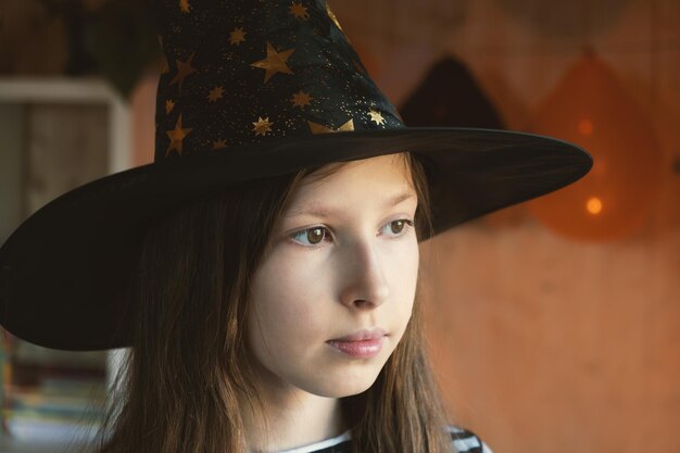 Photo halloween sad pensive girl in witch costume celebrating portrait of unhappy girl in masquerade hat