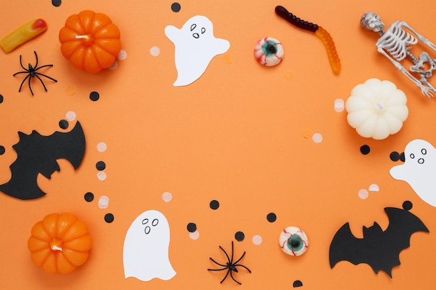 Foto halloween set decorazioni con zucche fantasma ragni pipistrello e scheletro su sfondo arancione