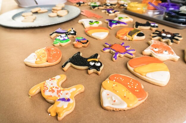 Halloween-suikerkoekjes versieren met kleurrijke royal icing.