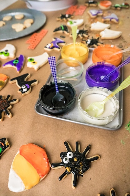 Halloween-suikerkoekjes versieren met kleurrijke royal icing.