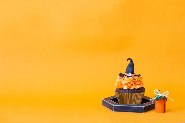 ハロウィーンのシンボル、休日の準備。オレンジ色のカボチャのカップケーキと木の装飾。