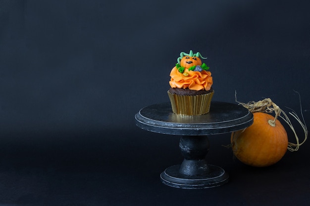 Halloween symbols, preparation for the holiday. Orange pumpkin cupcakes and wood decor.