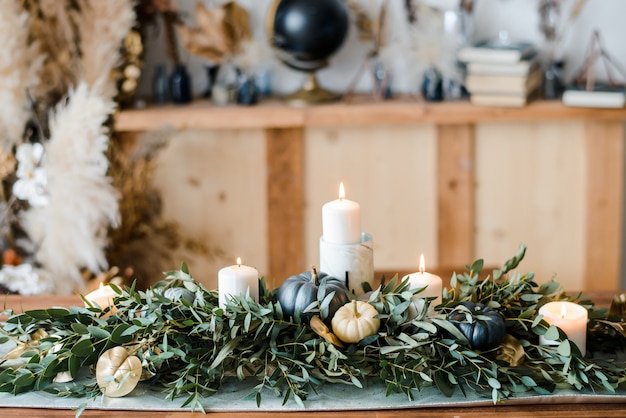 Halloween Table setting on dark background. Dish with sweets s on a dark table with black and gold pumpkin. Flat lay, top view trendy holiday concept.